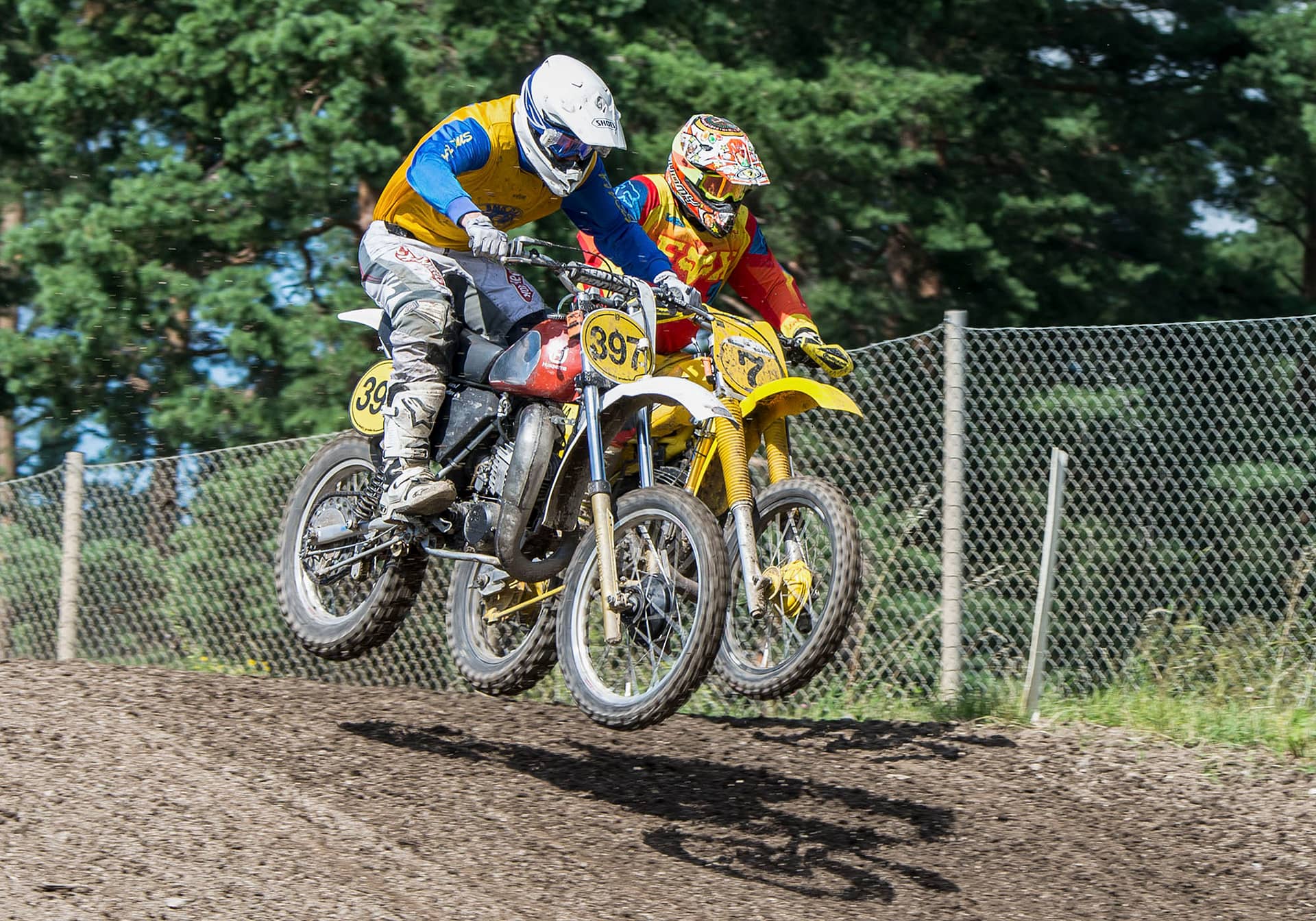 Två motocross-mc sida vid sida i luften